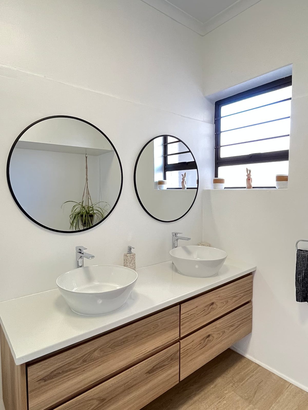 Bathroom at Atlantic Apartment with a double vanity and round mirrors