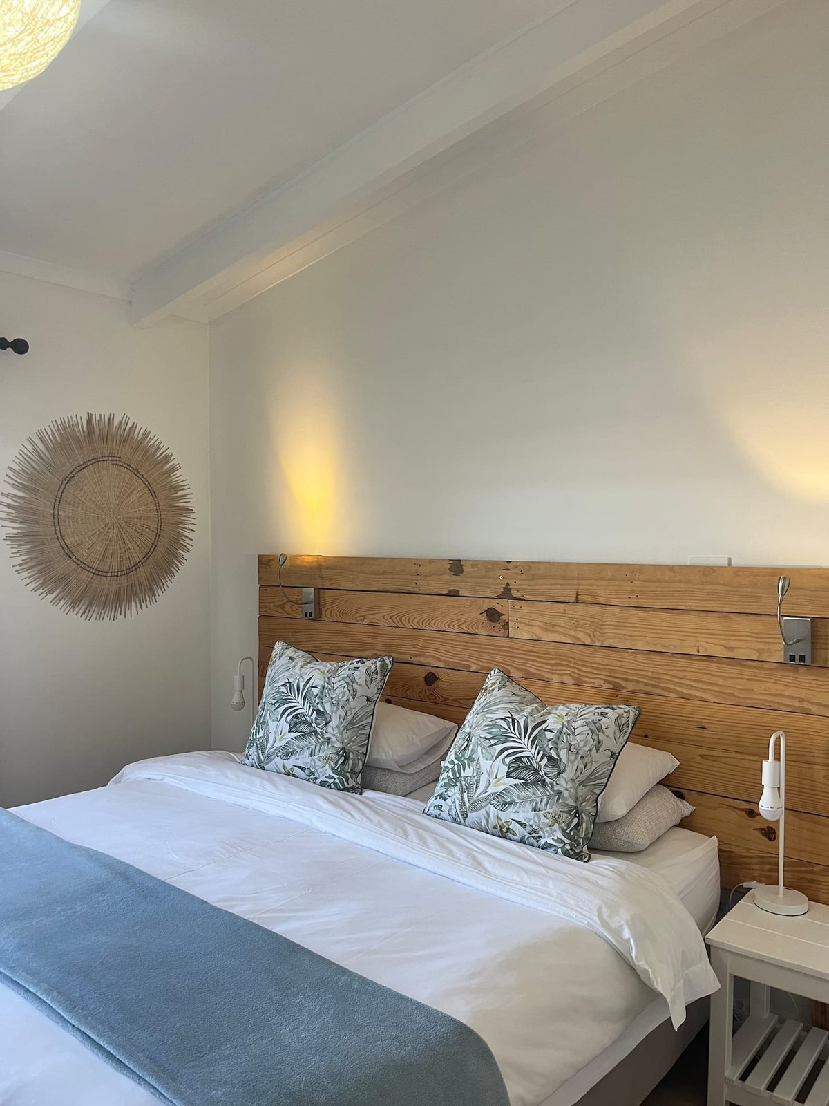 King bedroom at Atlantic Beach Cottage with a reclaimed-wood headboard and reading lights