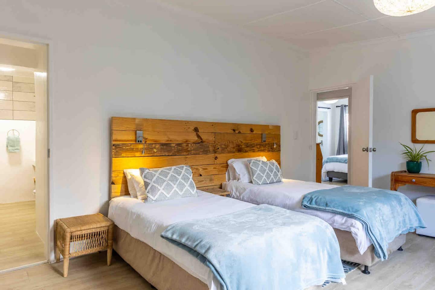 Twin bedroom at Atlantic Beach Cottage with two single beds, opening onto its own en-suite bathroom