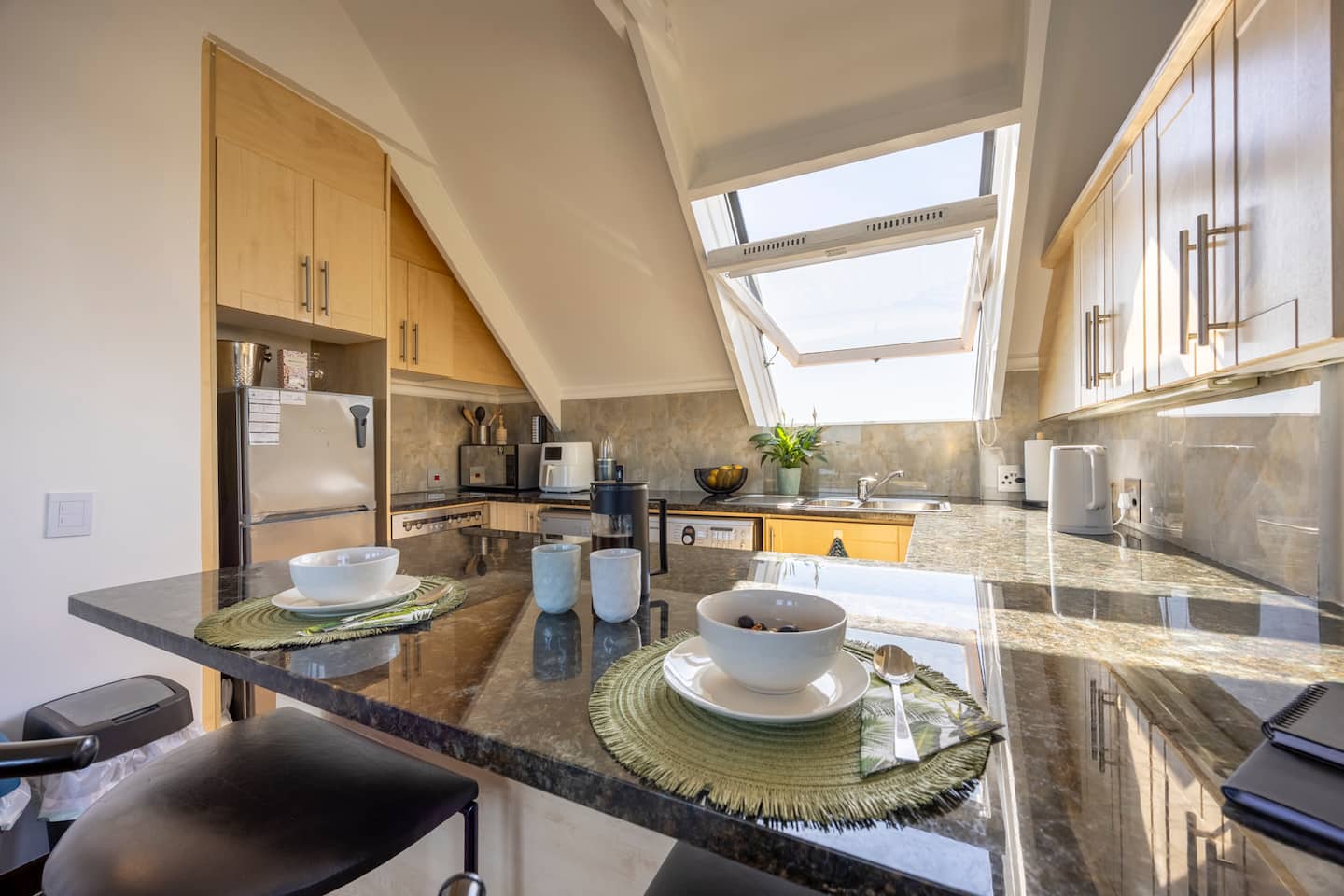 Kitchen at Atlantic Seaview with granite countertops, a breakfast bar and a skylight window open to the sea